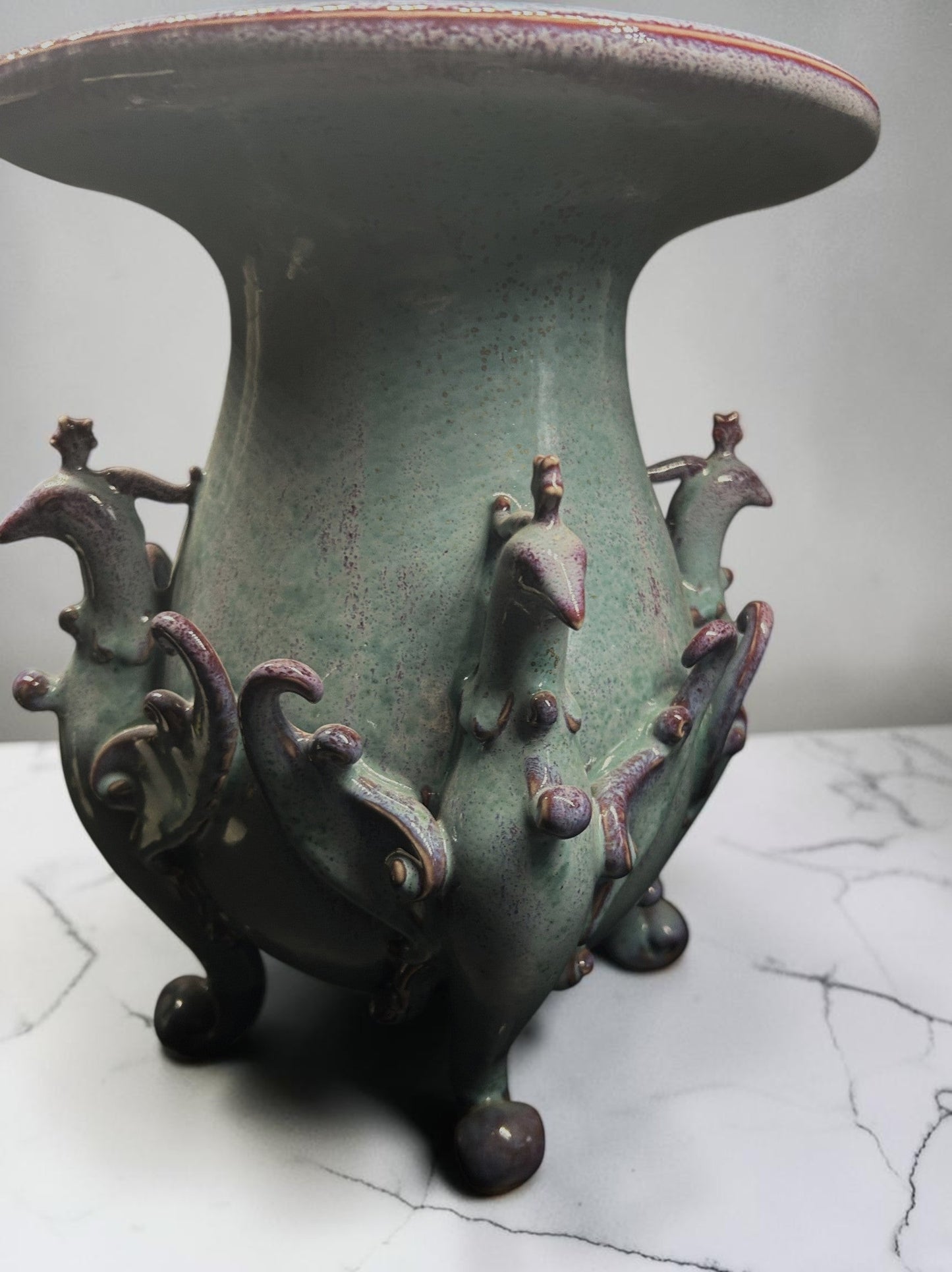 C&C Atelier celadon ceramic vase with purple peacock motifs and tripod base.