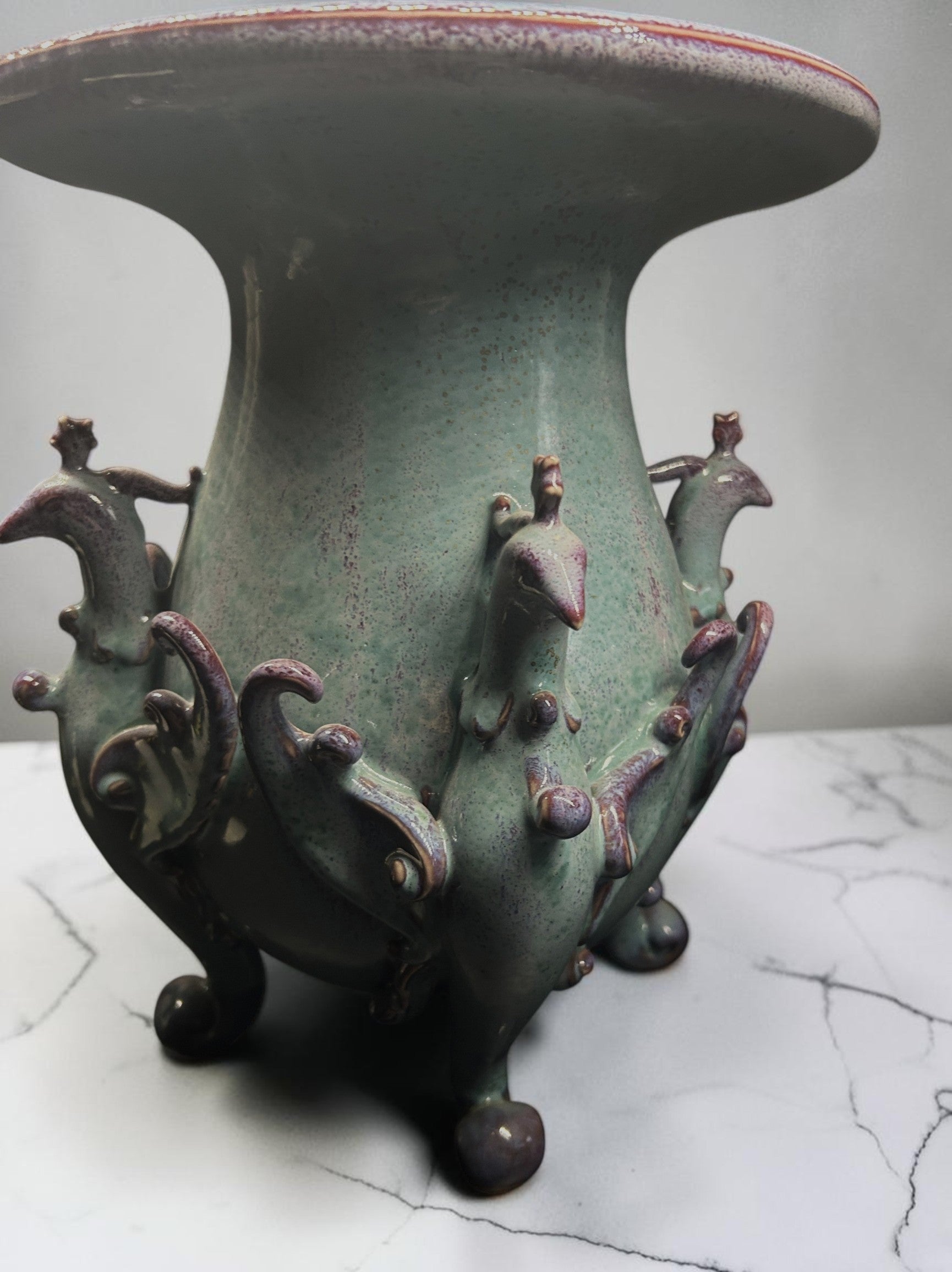 C&C Atelier celadon ceramic vase with purple peacock motifs and tripod base.