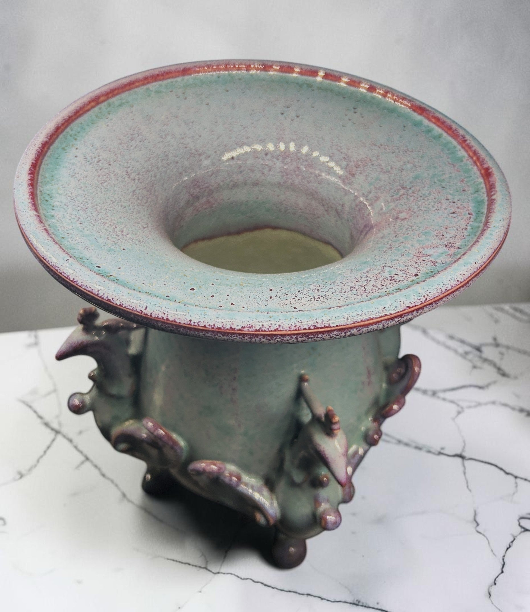 C&C Atelier celadon ceramic vase with purple accents and sculpted bird motifs on a tripod base.