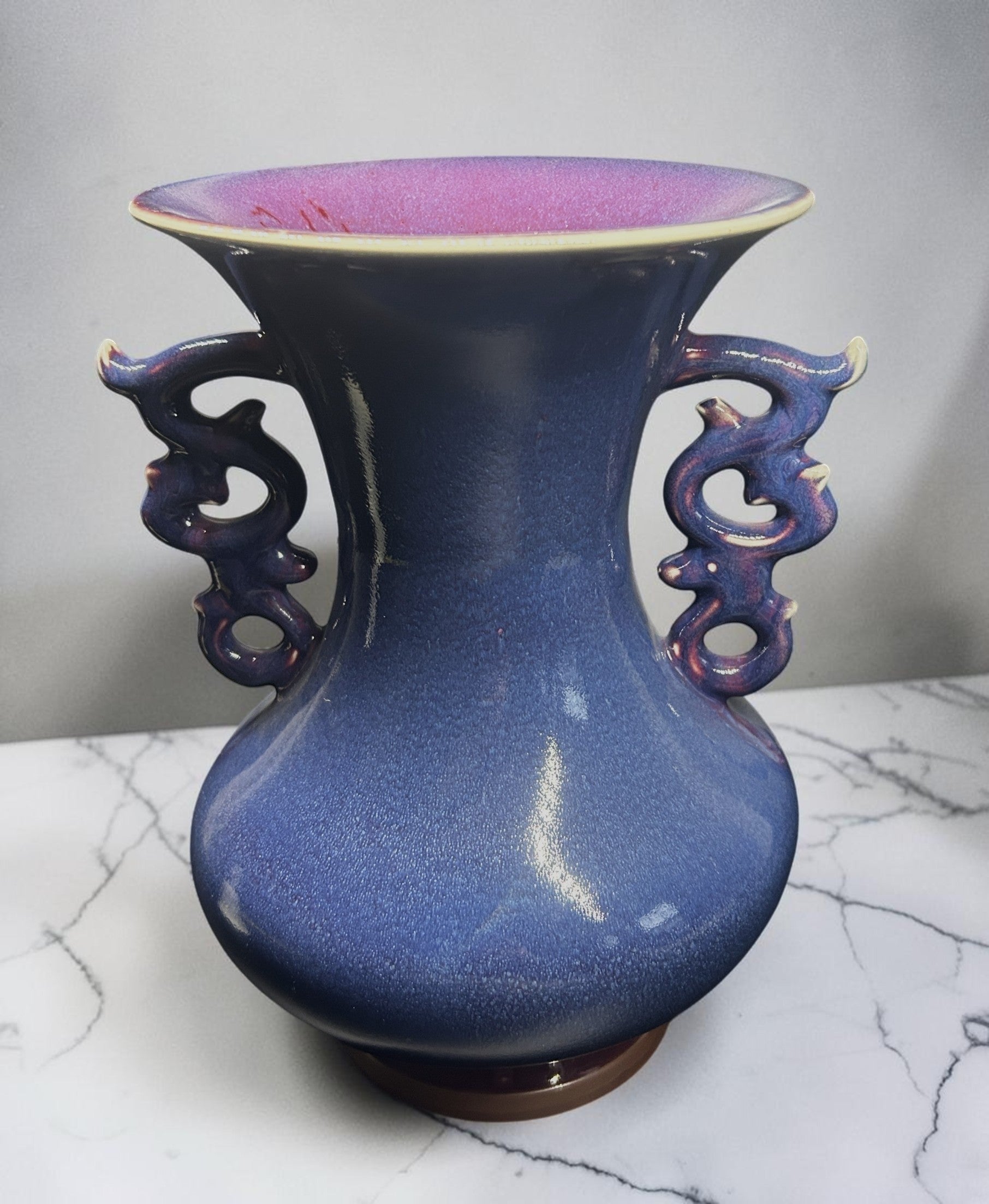 C&C Atelier decorative blue ceramic vase with flared rim and dragon-inspired handles, purple interior.