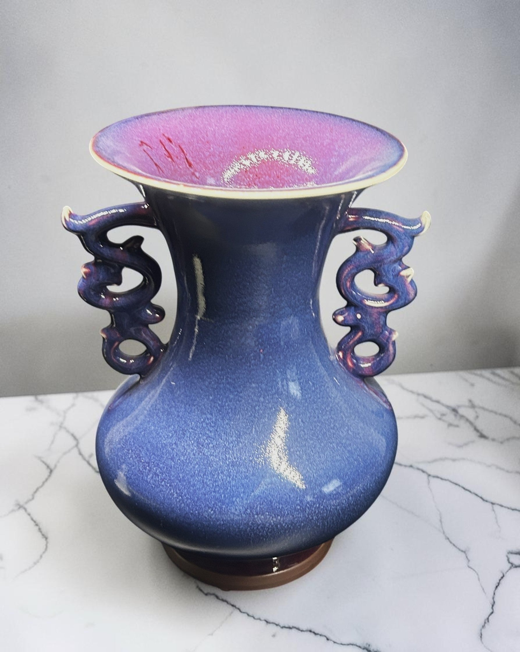 C&C Atelier deep blue ceramic vase with flared rim and dragon-shaped handles, purple interior.