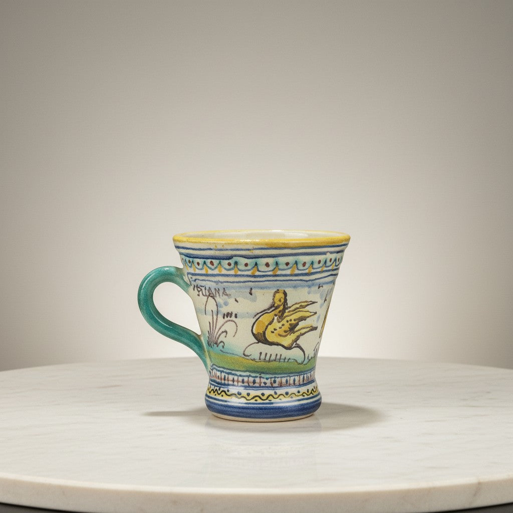 C&C Atelier hand-painted ceramic mug with yellow bird and blue floral motifs. Features a teal handle and yellow rim.