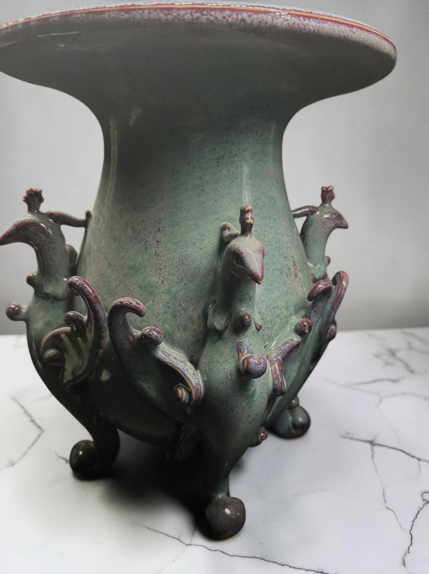 C&C Atelier celadon ceramic vase with purple peacock motifs and tripod base.